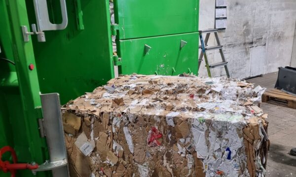 gepresster Papierballen fällt aus Ballenpresse auf Palette