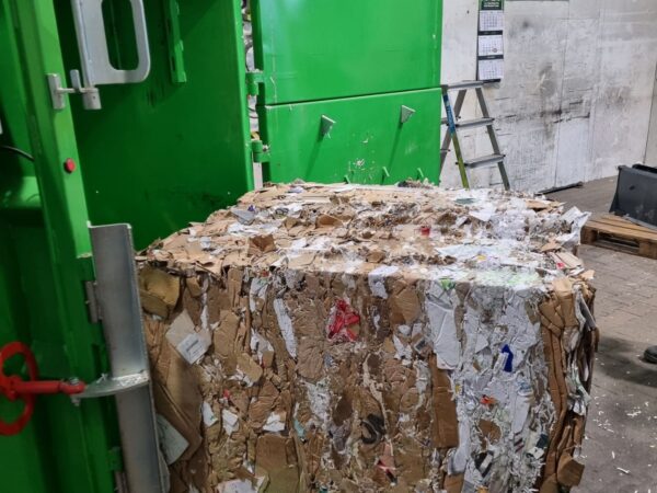 gepresster Papierballen fällt aus Ballenpresse auf Palette