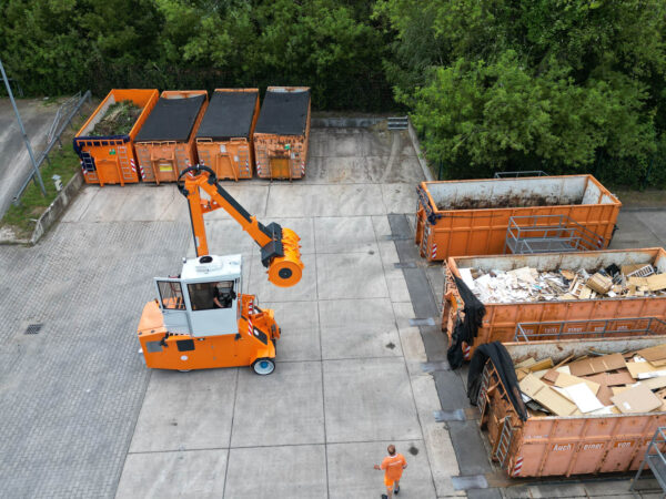 mobiler Walzenverdichter fährt zu einem Container