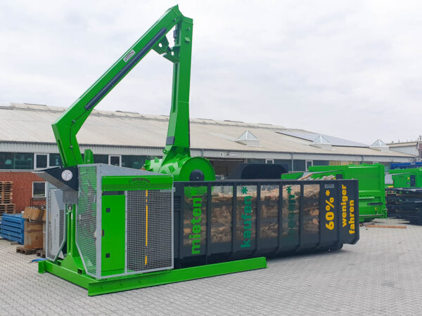 Walzenverdichter verdichtet Holz in Container