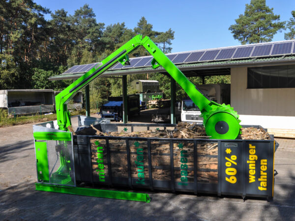 Roll-Packer verdichtet Holz in Container